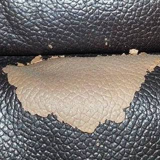 Picture of top-grain leather with a brown urethane paint that has peeled away revealing the original color and same texture