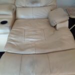 Photo of worn and discolored leather reclining loveseat