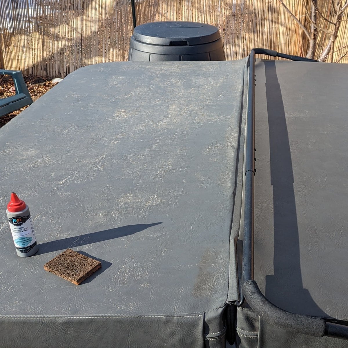 Picture of hot tub cover mid-restoration, showing custom Rub n Restore grey vinyl protector on right side and original vinyl on left