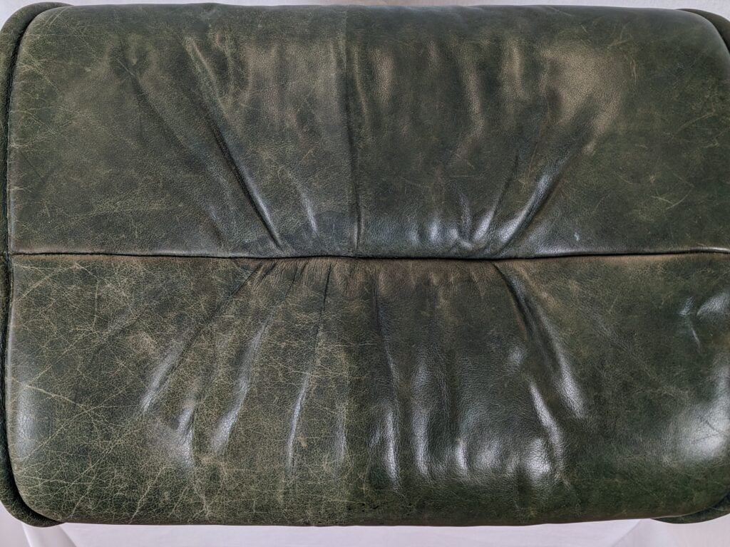 Picture of Ekornes semi-aniline leather ottoman. The left side is worn and looks sun-faded. The right side was restored simply with a coat of Clear Prep+Finish.