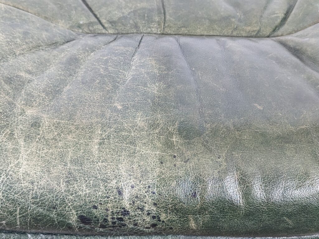 Close-up of stains on side of ottoman not corrected or hidden with clear finish.