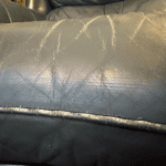Picture of leather chair cushion showing discoloration and wear along the front edge and piping