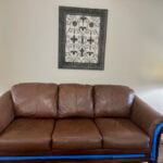Picture of leather couch restored with Cinnamon color Rub 'n Restore leather paint. Disregard blue painters tape to protect trim.