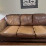 Picture of discolored, faded light brown leather couch.