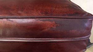 Picture of leather cushion damaged by mineral deposits after saturation with water.