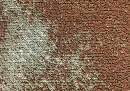 UV damage has caused this rust marine vinyl to dry out and flake away, exposing a woven mesh.