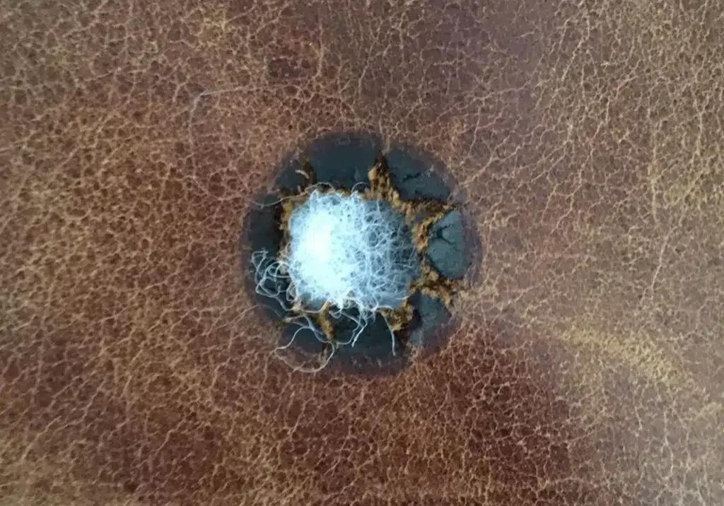 The burn in this leather just needs to be trimmed, subpatched, and repaired with filler.