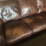 Close-up of yellowed, faded spots on leather couch