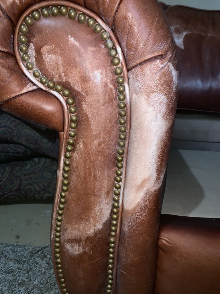 Photo of leather couch arm damaged by mineral deposits