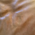 Close-up photo of leather cushion after repair and Rub n Restore Tobacco color