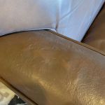 Picture of hole in leather chair arm after repair and one coat of color